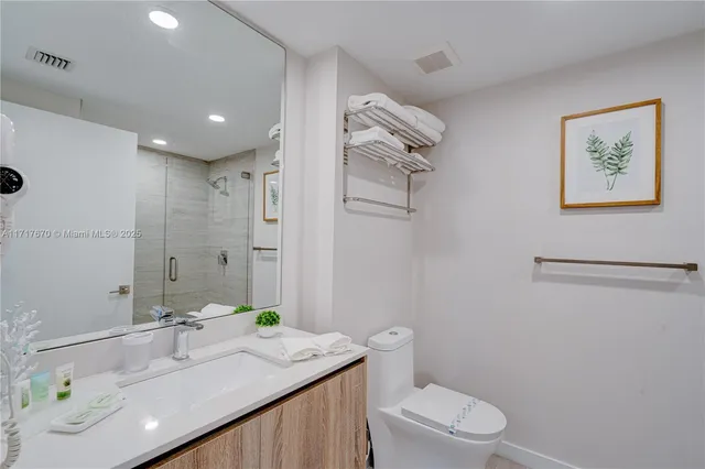 a bathroom with a granite countertop sink a toilet and a mirror