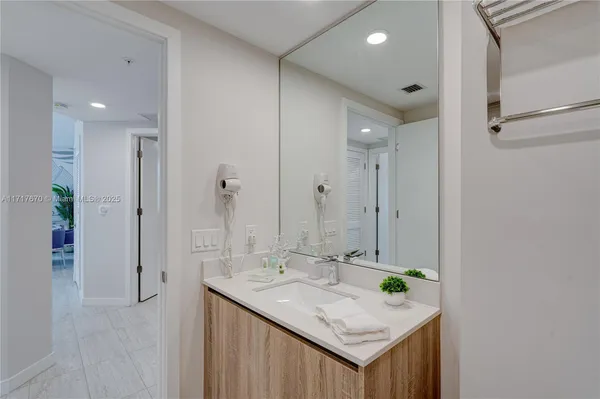 a bathroom with a granite countertop sink and a mirror