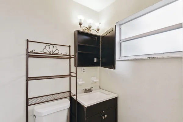 a bathroom with a toilet a sink and mirror