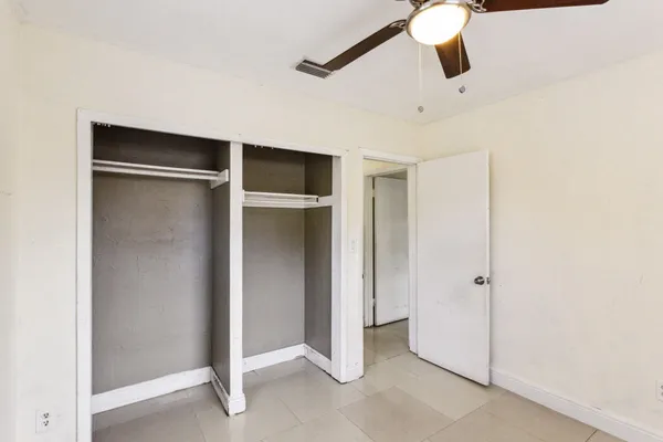 a bedroom with a large bed and a ceiling fan
