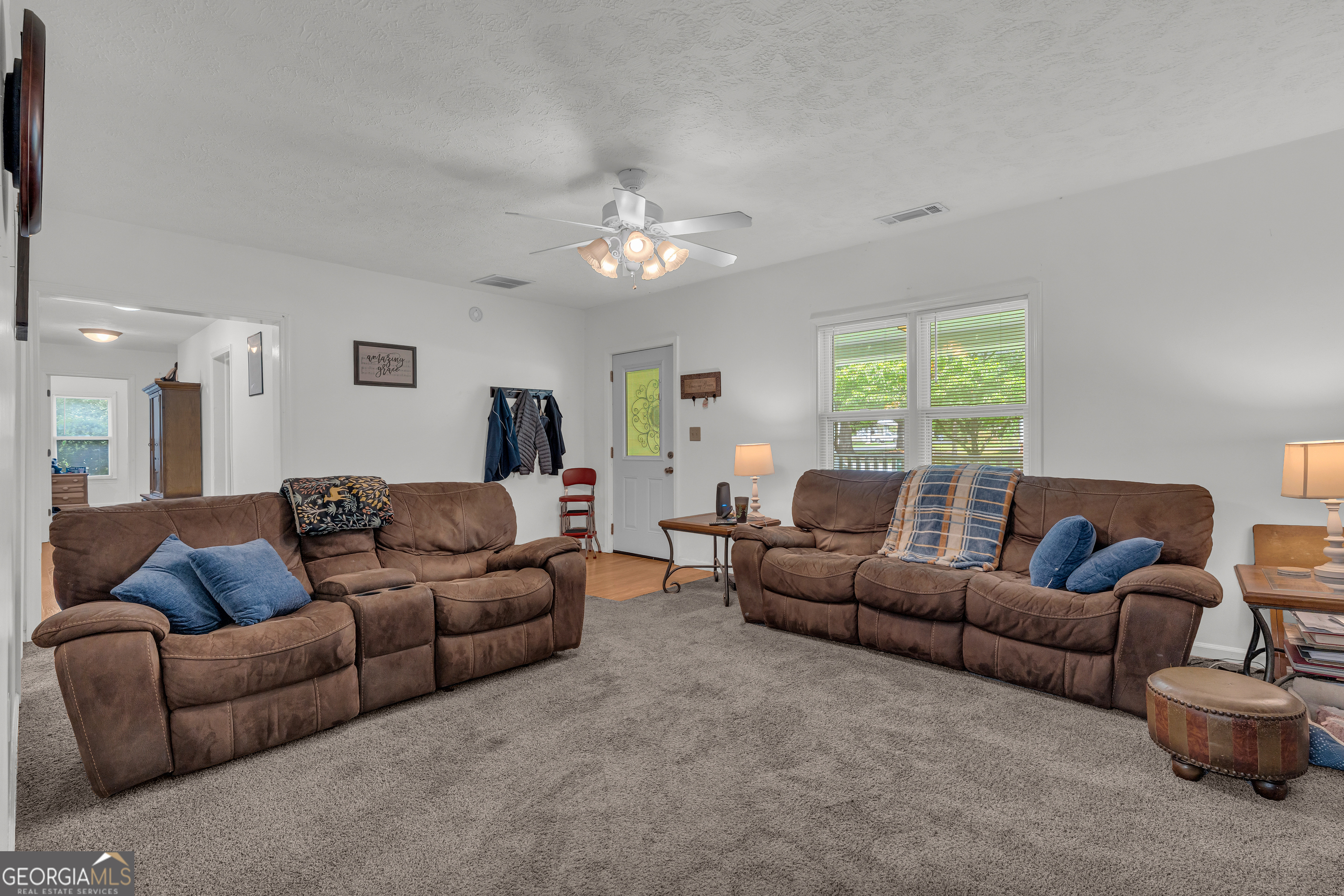878 Jackson Street Locust Grove, GA 30248 - Photo 15 of 65 a living room with furniture a chandelier and a couch