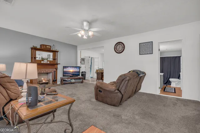 a living room with furniture a fireplace a dining table and a window