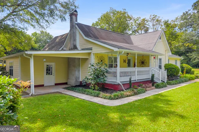 a view of a house with a yard and potted plants