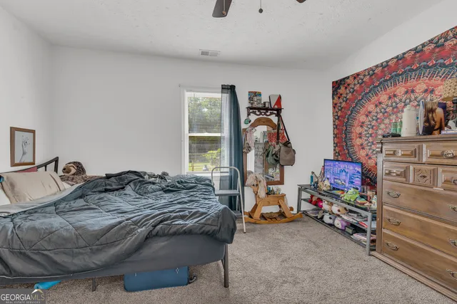 a spacious bedroom with a bed and a chandelier