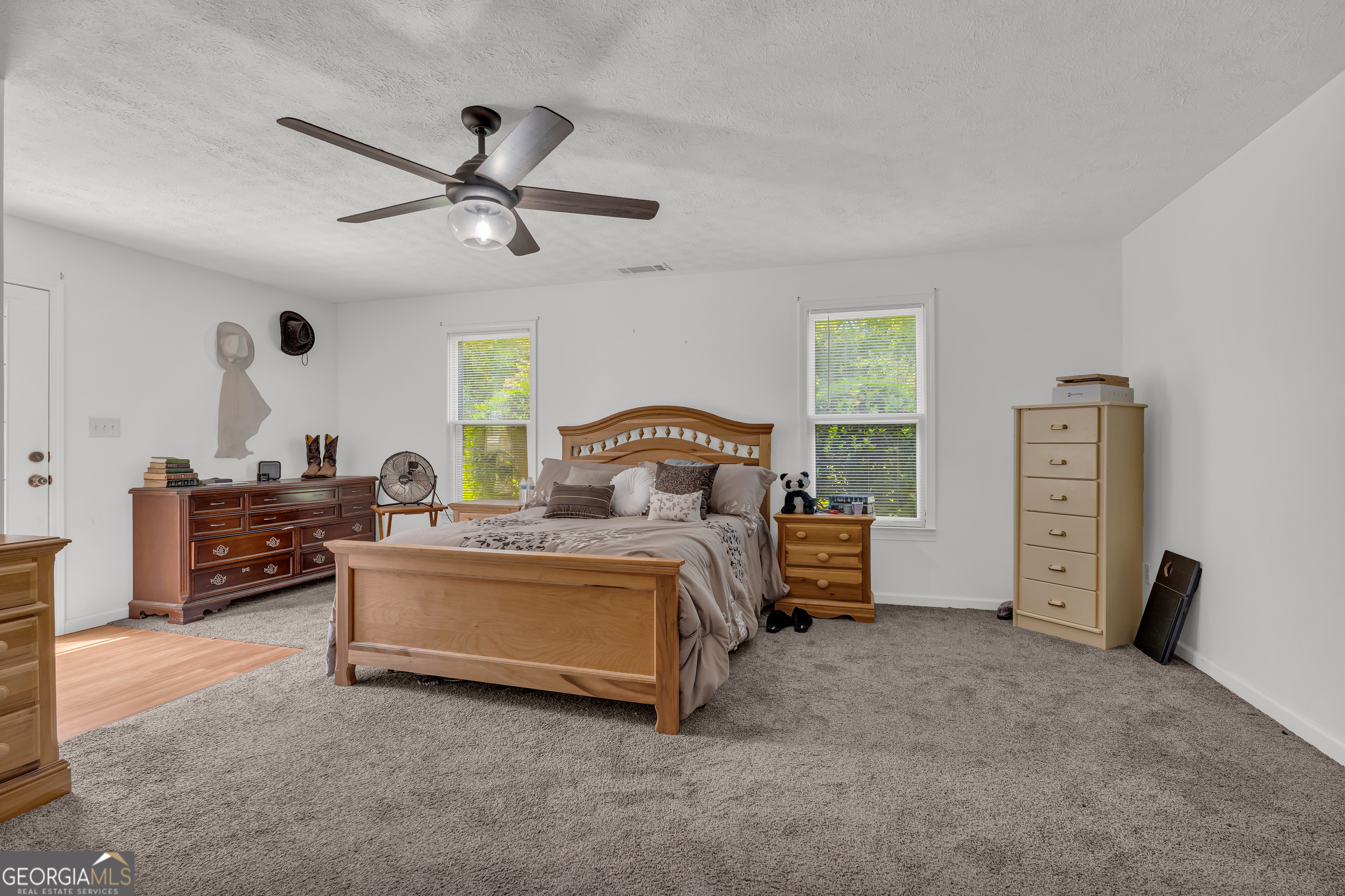 878 Jackson Street Locust Grove, GA 30248 - Photo 37 of 65 a spacious bedroom with a bed and a chandelier
