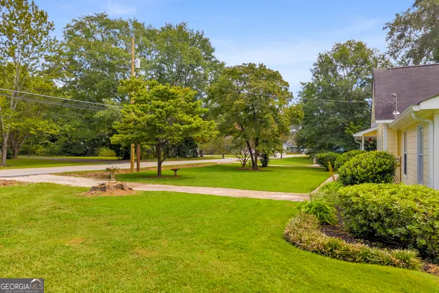 a view of a house with a small yard and wooden floor and fence