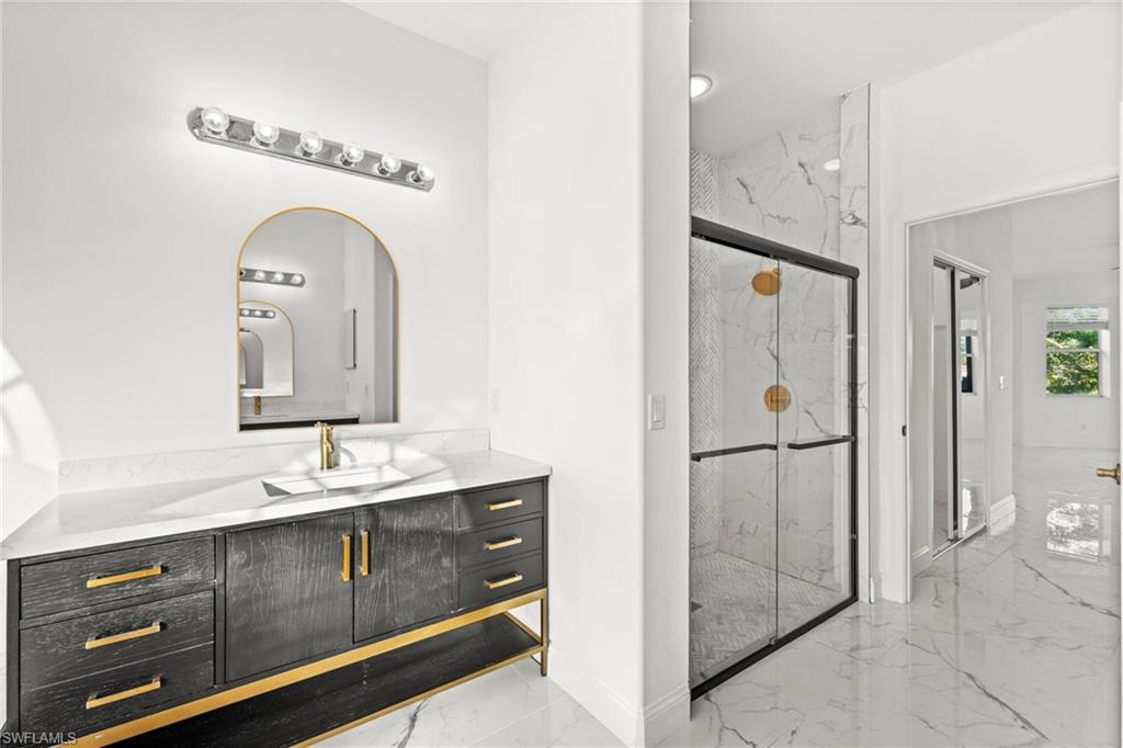 3972 Ruxton Road Naples, FL 34116 - Photo 21 of 41 a bathroom with a sink a mirror and a shower