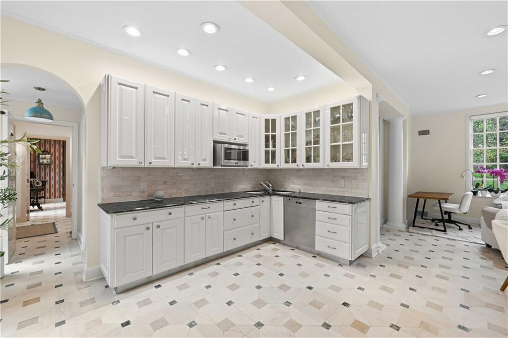 898 Persimmon Road Sewickley, PA 15143 - Photo 19 of 50 The kitchen opens with crisp white cabinetry, marble counters, and graceful arched transitions that carry the home’s classic architectural language throughout.