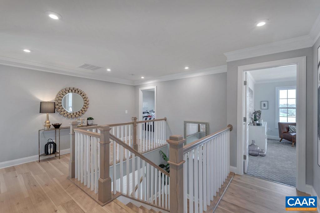 25 Wexford Ridge Road Ruckersville, VA 22968 - Photo 24 of 41 a view of a hallway with wooden floor stairs and a livingroom with furniture