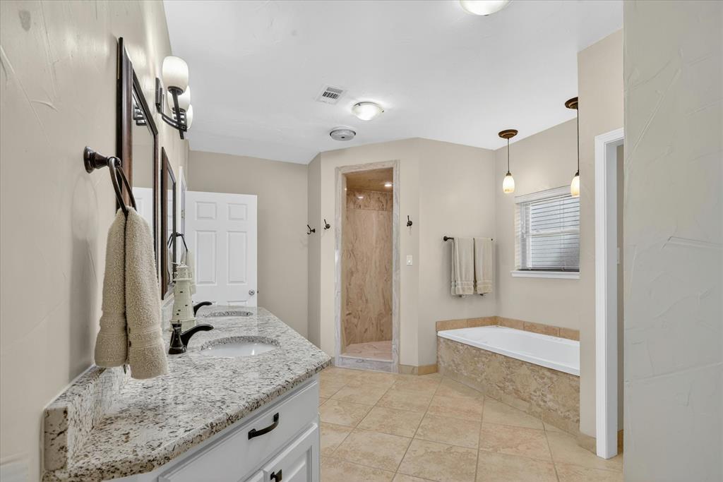 8877 Random Road Fort Worth, TX 76179 - Photo 16 of 40 a bathroom with a granite countertop sink a toilet and shower