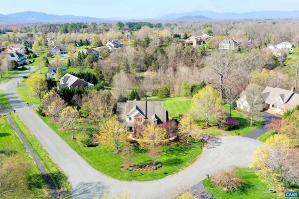 an aerial view of a house with a garden and mountains