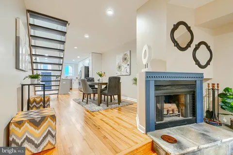 a living room with furniture a fireplace and a floor to ceiling window