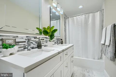 a bathroom with a sink a mirror and a shower