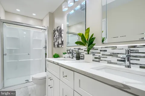 a bathroom with a granite countertop sink a toilet and a shower
