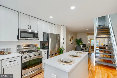 a kitchen with stainless steel appliances a stove a sink and a refrigerator