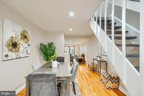 a view of a dining room with furniture a potted plant and wooden floor