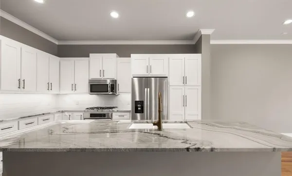 a large kitchen with stainless steel appliances granite countertop a stove a sink and a refrigerator