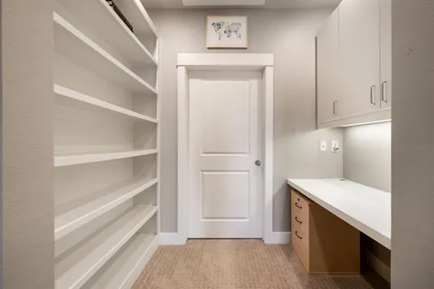 an empty room with windows and ceiling fan
