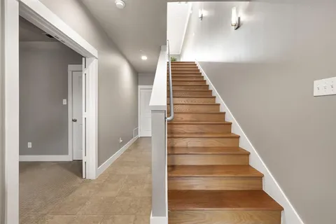 an empty room with a chandelier fan and windows