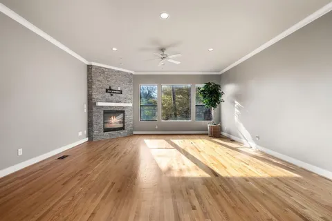 a view of empty room with wooden floor and fireplace