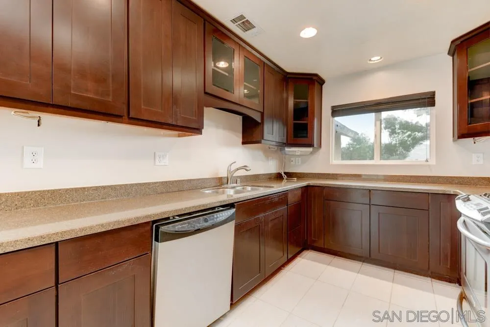 11949 Rocoso Road Lakeside, CA 92040 - Photo 8 of 27 a kitchen with stainless steel appliances granite countertop wooden cabinets a sink and a stove