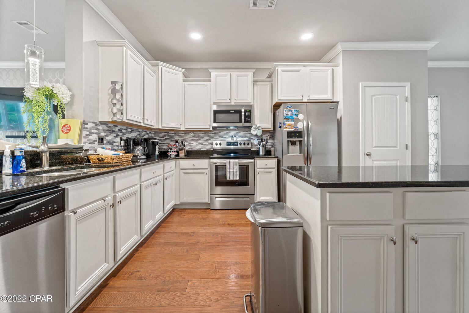 11 Topside Drive Inlet Beach, FL 32461 - Photo 13 of 31 a white kitchen with stainless steel appliances granite countertop a stove a sink and a refrigerator