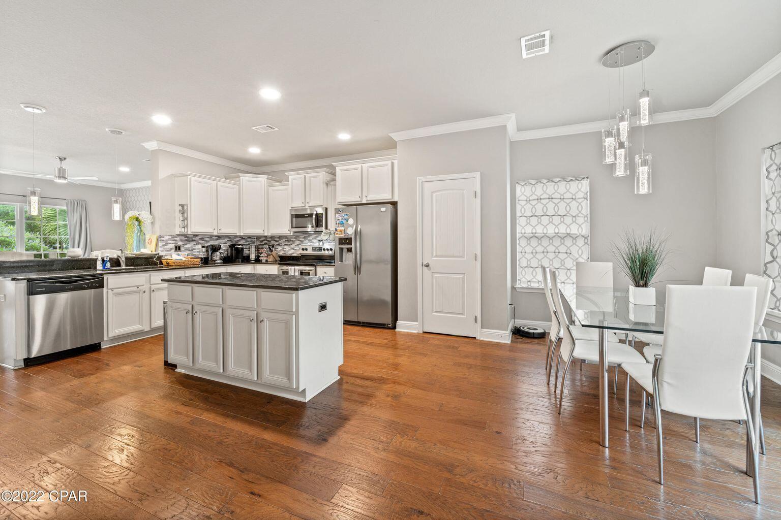 11 Topside Drive Inlet Beach, FL 32461 - Photo 15 of 31 a kitchen with stainless steel appliances kitchen island granite countertop a stove a sink a refrigerator and white cabinets with wooden floor