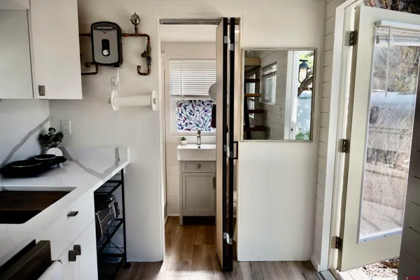 a kitchen with stainless steel appliances granite countertop a refrigerator and a wooden floor