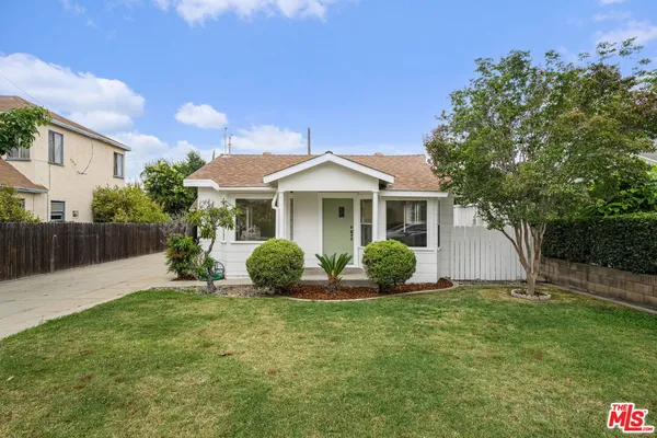 a front view of a house with a garden and yard