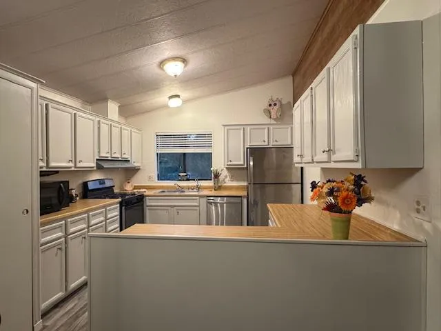 a kitchen with stainless steel appliances granite countertop a refrigerator sink and cabinets