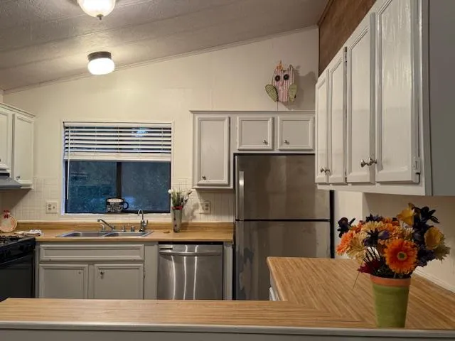 a kitchen with a refrigerator and white cabinets