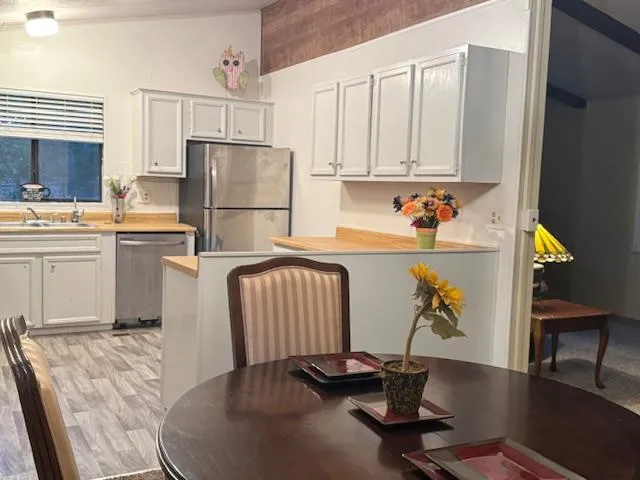 a kitchen with a dining table chairs and refrigerator