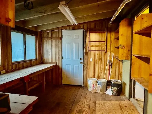 a view of a backyard with table and chairs potted plants and large tree