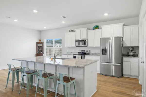 a kitchen with stainless steel appliances a refrigerator sink and microwave
