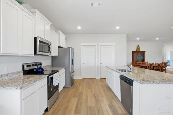 a kitchen with a sink stove top oven and refrigerator