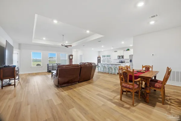 a living room with furniture and a dining table with kitchen view