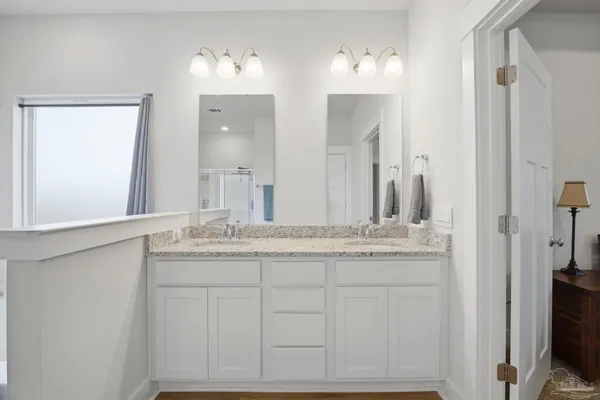 a bathroom with double sink and a mirror