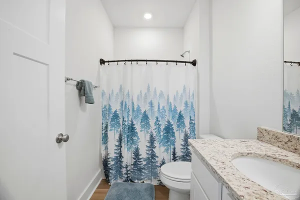 a bathroom with a granite countertop sink toilet and shower