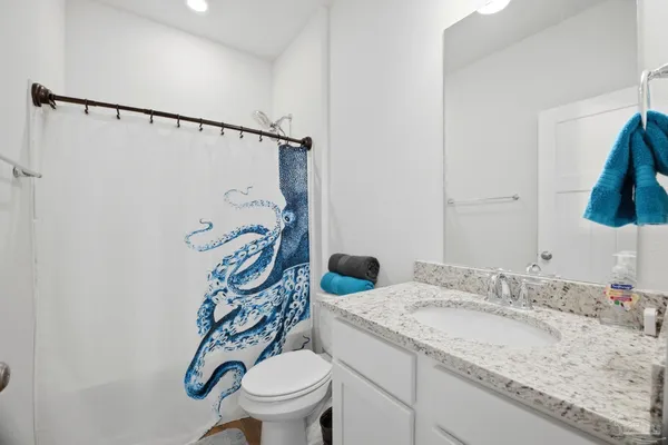 a bathroom with a granite countertop sink toilet and a mirror
