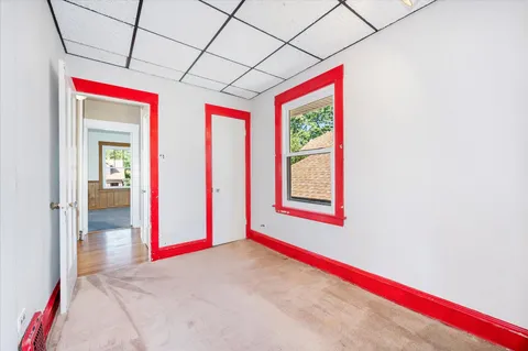 a view of a big room with wooden floor and a window