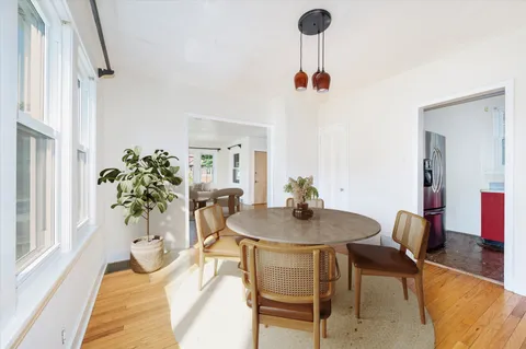 a view of a dining room with furniture and a potted plant