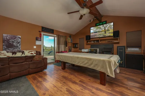 a spacious bedroom with a bed a flat screen tv and balcony view