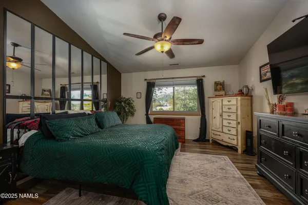 a living room with a bed furniture and a flat screen tv