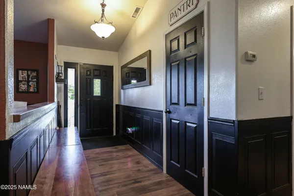 a kitchen with stainless steel appliances granite countertop a refrigerator and a wooden floor