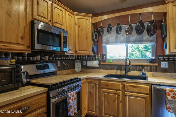 a kitchen with stainless steel appliances granite countertop a sink a stove and a microwave