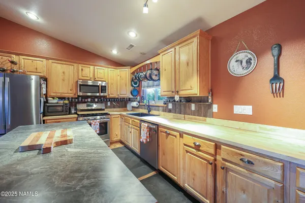 a large kitchen with a large window and stainless steel appliances