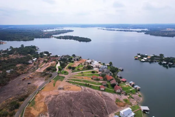 a view of a house with a yard and potted plants