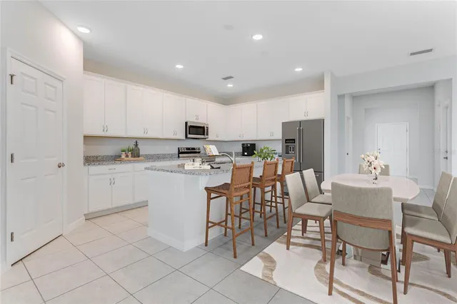 a kitchen with a sink white cabinets and stainless steel appliances