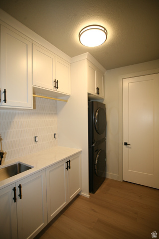 635 East Mountain Road North Ogden, UT 84414 - Photo 7 of 33 Laundry room featuring white shaker cabinetry, an integrated stainless steel utility sink, light-toned countertop, and a decorative tile backsplash
