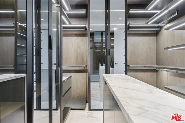 a kitchen with stainless steel appliances kitchen island granite countertop a refrigerator and a glass door shower